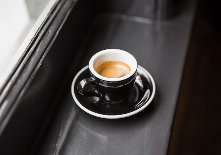 Czarna filiżanka kawy espresso lungo na parapecie