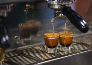 Ristretto - kawa dla precyzyjnych Według międzynarodowego Stowarzyszenia Kaw Specjalnych (Specialty Coffee Association) tradycyjny przepis na espresso to 25-35 ml (ok. 20-30g) napoju przygotowanego na bazie 7-9 gram zmielonej kawy parzonych wodą o temperaturze ok. 92-95 stopni Celsjusza, pod ciśnieniem 9-10 bar statycznego ciśnienia, przez 20-30 sekund. Ten przepis stanowił punkt wyjściowy w opisanych wyżej badaniach, ale nie będziemy opisywać ich bardziej szczegółowo. Użyjemy jednak tego przepisu, aby wyjaśnić najbardziej popularną formułę ristretto. Najkrótsze wersja przepisu na caffe ristretto: espresso podzielić na dwa. - W trakcie przygotowywania porannej filiżanki kawy można po prostu zatrzymać ekspres, kiedy w filiżance jest już 15 ml (ok. 15 g) kawy. Każdy, kto spróbuje tego "szotu" przekona się, że ristretto nie jest tak bogate w smaki jak espresso, ale jest w nim także mniej charakterystycznej, kawowej goryczy. - Klasyczny szot ristretto i najbardziej rozpowszechniony przepis polega na zaparzeniu 15 ml (15g) kawy w 15 sekund lub np. 18 ml (18g) kawy w 22 sekundy. Konieczne jest odpowiednie ustawienie ekspresu i gotowe. - Trzeci popularny przepis to nieco drobniej niż zazwyczaj zmielona kawa, ale "standardowy" czas zaparzania, czyli 25-30 sekund. Aby wyjaśnić czym jest ristretto i jak różni się jego smak od klasycznego espresso można porównać je z brownie. Jest to czekoladowe ciasto, które ma zazwyczaj dość gęstą, zbitą konsystencję. Są jednak brownie mniej i bardziej zbite, zawierające mniej i więcej czekolady. Te najtwardsze, najbardziej czekoladowe brownie są właśnie niczym espresso ristretto. Koncentrację czekolady można uzyskać na różne sposoby – albo dodając mniej wody, albo używając większej ilości czekolady. Podobnie jest z kawą.